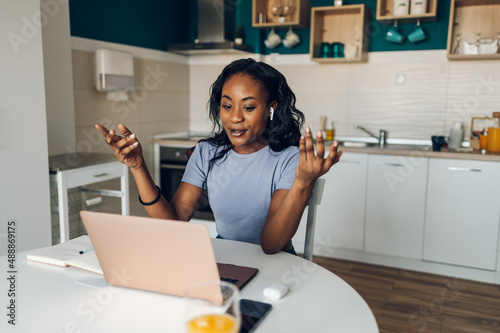 Young african american woman working from home and using a laptop