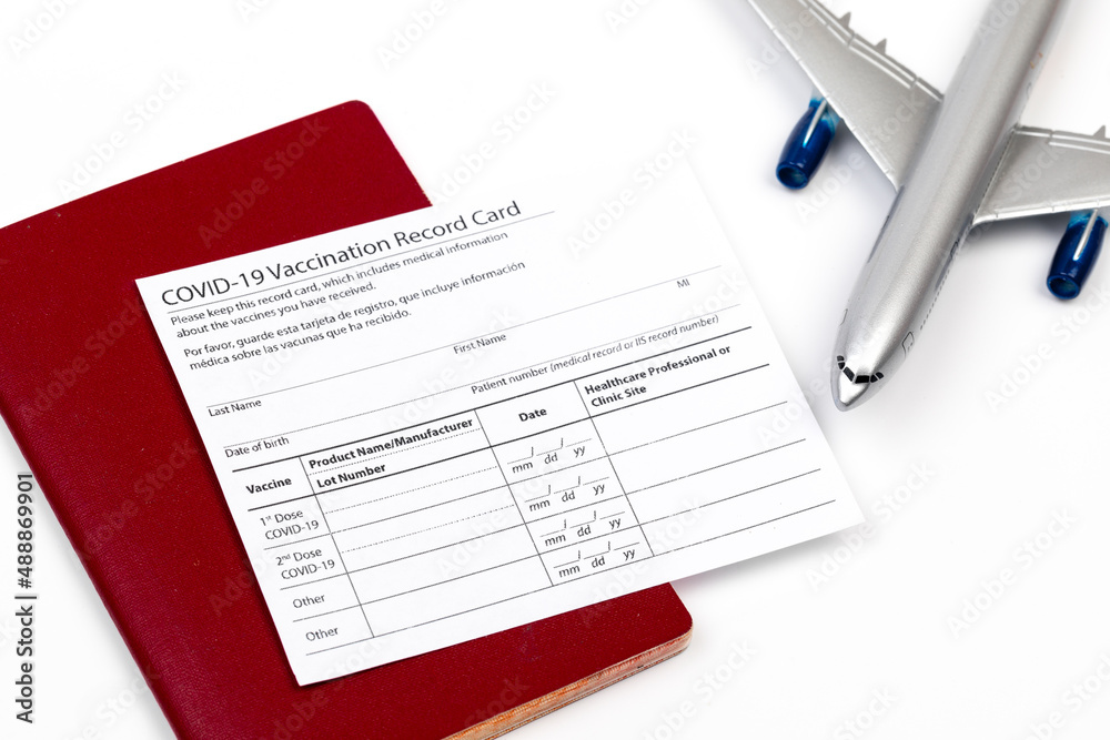 Obraz premium COVID-19 vaccination record card and tourist passport of traveler for worldwide travel during coronavirus pandemic. - Image