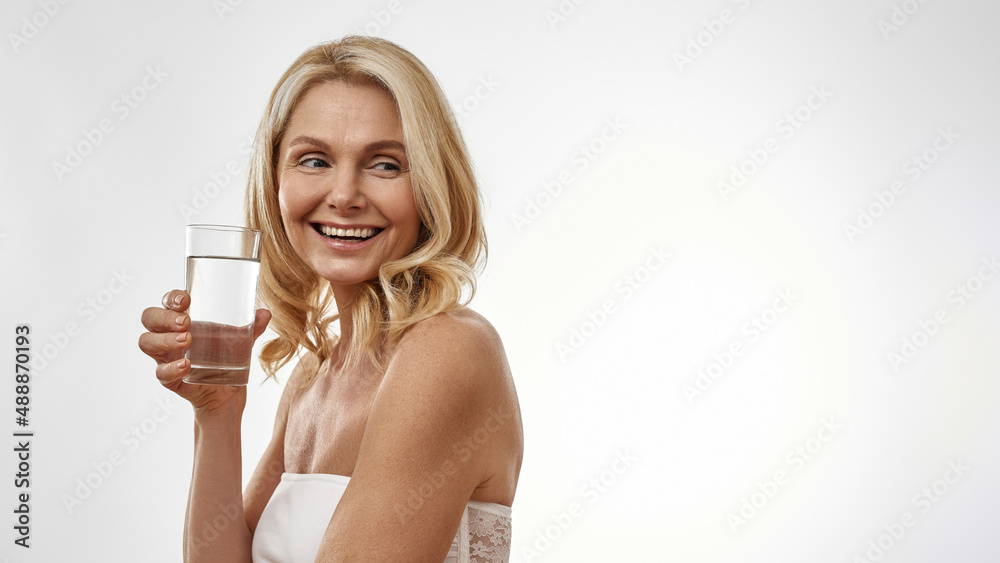 Pleased middle aged woman holding glass with water Pleased middle aged woman holding glass with water