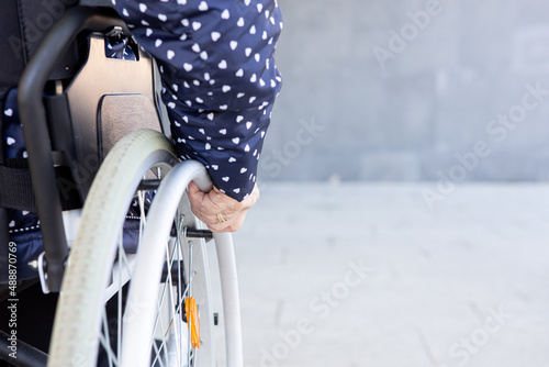 Photos Elderly person with dependency and mobility problems due to bone disease sitting in a wheelchair