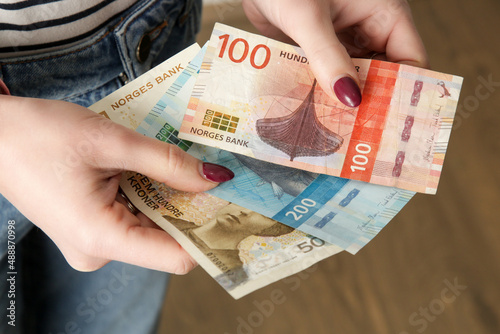 Woman holding Norwegian krone banknotes