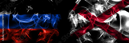 Donetsk People's Republic vs Alabama, Alabamian flag. Smoke flags placed side by side isolated on black background. photo