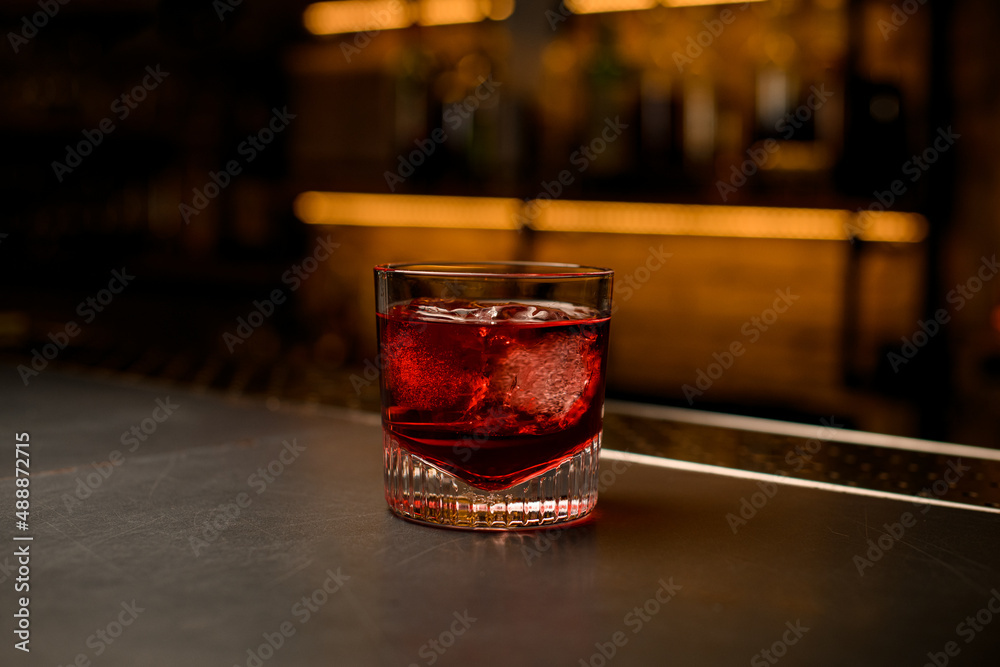 great view of old-fashioned glass with a bright red cold beverage stands on bar