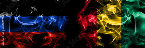 Donetsk People s Republic vs Guinea flag. Smoke flags placed side by side isolated on black background.