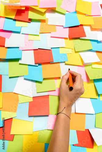 hand writing on a surface full of self-adhesive note-taking papers