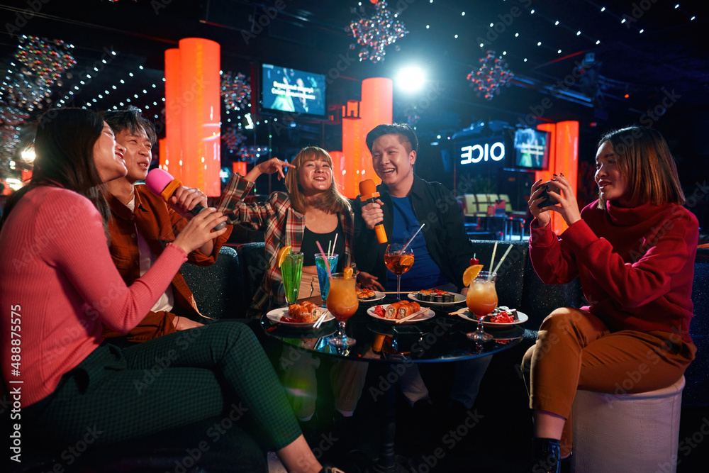 Group of friends having fun and celebration at karaoke club