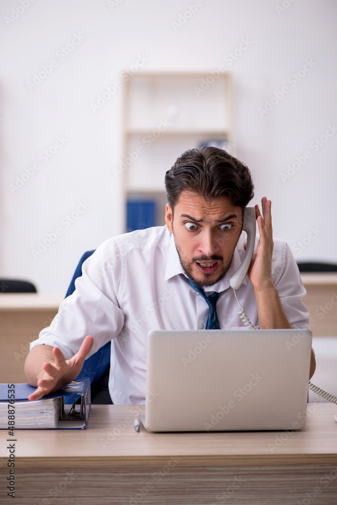 Young male employee working in the office Young male employee working in the office