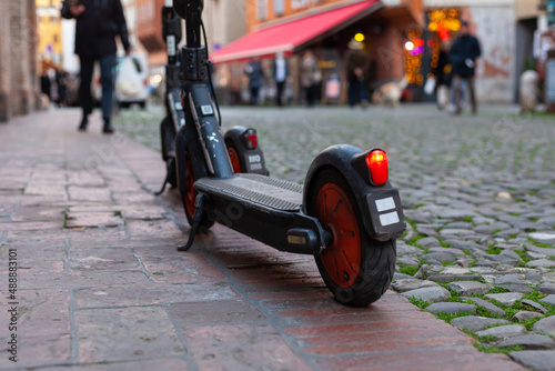 Two electric scooters parked on a footpath in Modena city center, Italy