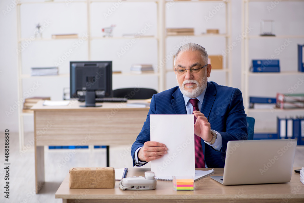 Old male employee working in the office