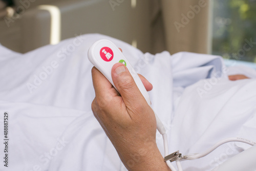 Patient press the help button for nurse calling in case of emergency in the hospital