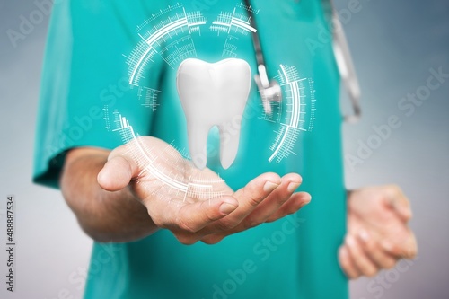 The dentist looks at the hologram of the tooth. Concept for innovative technologies, medicine of the future, tooth snapshot.