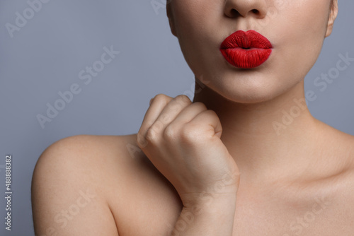 Closeup view of beautiful woman puckering lips for kiss.on grey background