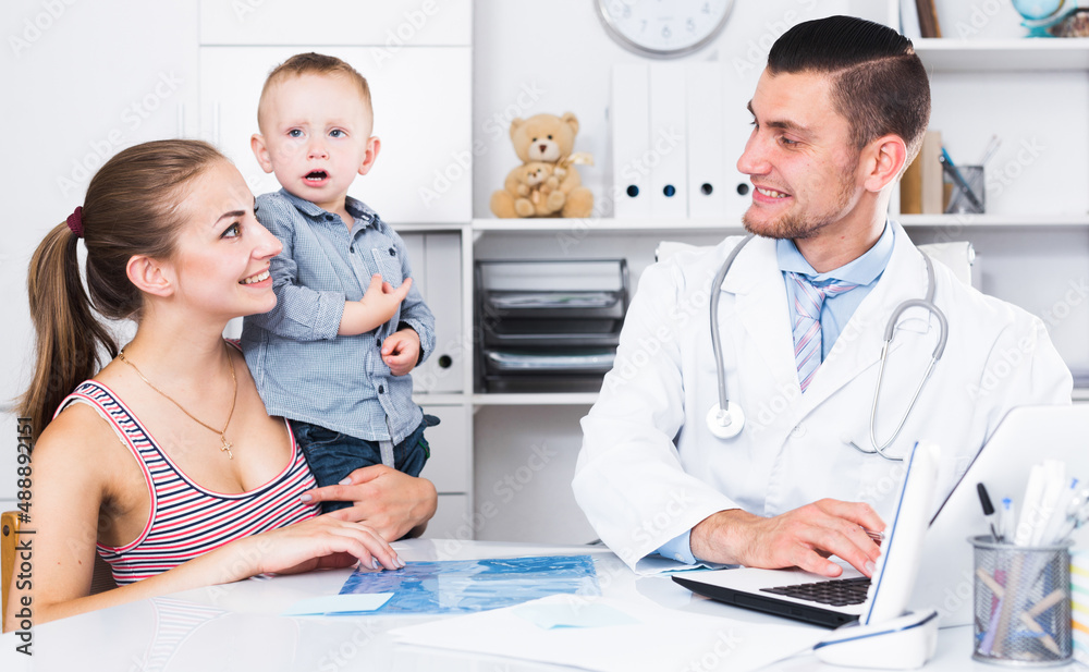 Obraz premium Adult male doctor leading medical appointment the young woman and child