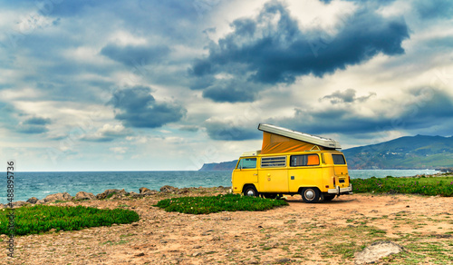 Wallpaper Mural yellow camper van standing in front of the sea on a cliff with dramatic sky - travel concept. Torontodigital.ca