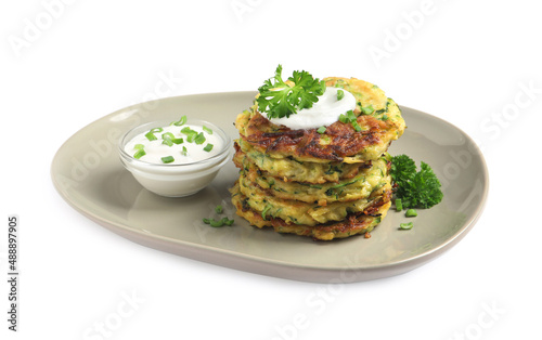 Delicious zucchini fritters with sour cream on white background