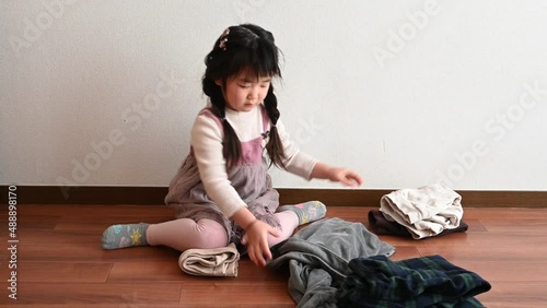 Girl helping to fold family laundry