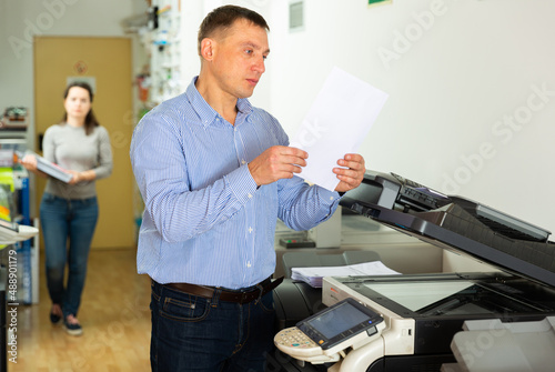 Worker is printing a file, document in the office room. High quality photo