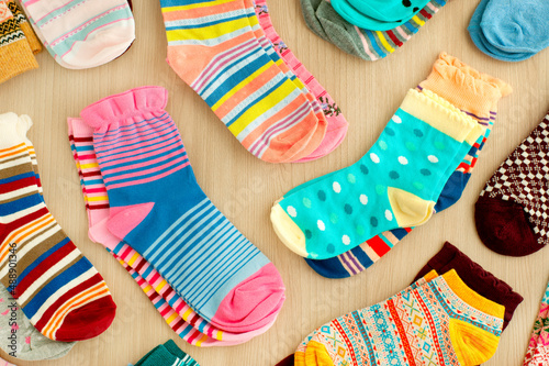 Socks are folded into piles. Many multi-colored socks on a wooden background. Clothes in the form of socks.