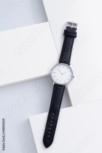 Men's watch with leather strap and white dial, isolated on a white background