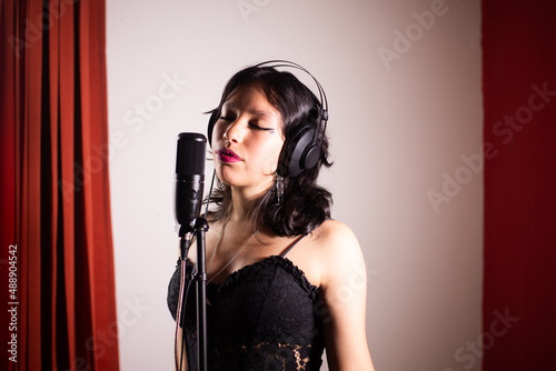 Mujer joven cantando emocionada en un estudio