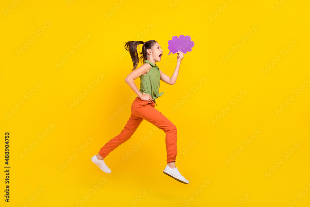 Photo of excited funny student girl wear green shirt smiling jumping high running fast mind cloud empty space isolated yellow color background