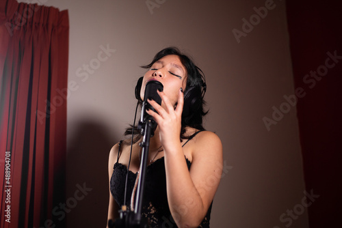 Mujer joven cantando emocionada en un estudio photo