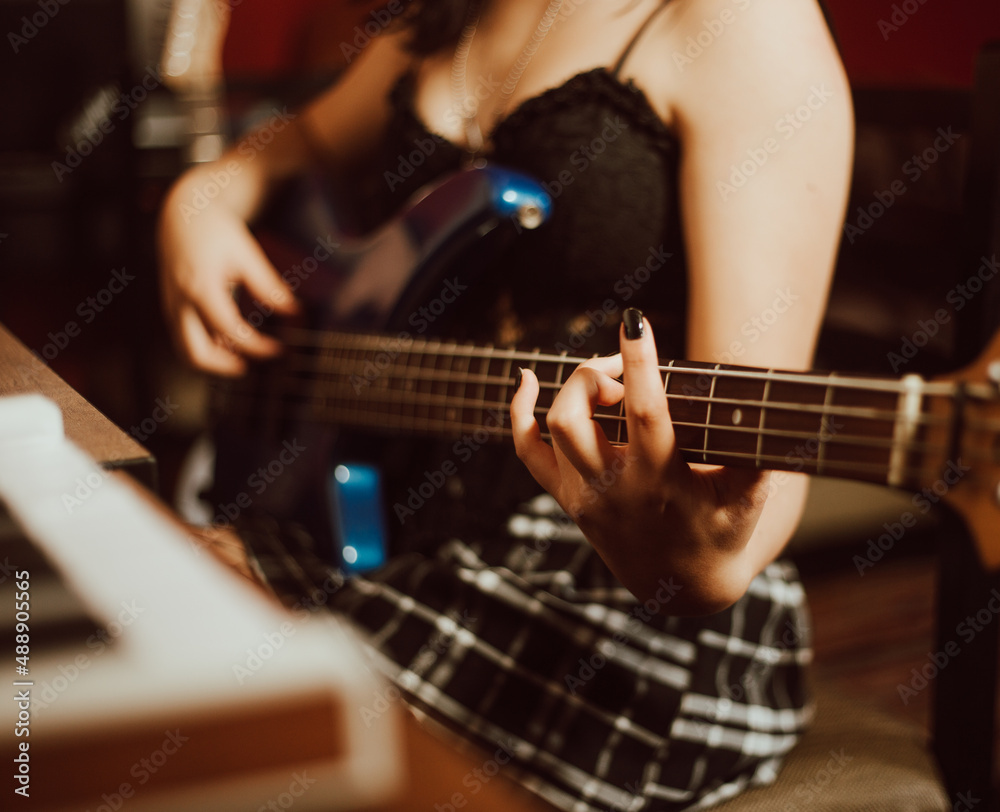 Fototapeta premium manos de mujer tocando el bajo en un estudio