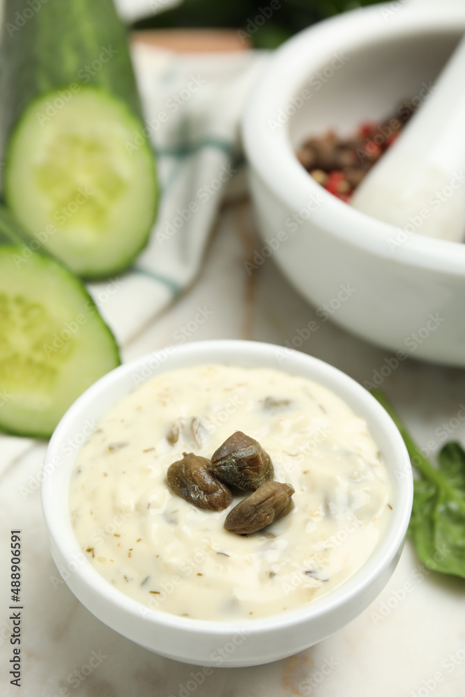 Creamy caper sauce in bowl on white table, closeup Creamy caper sauce in bowl on white table, closeup
