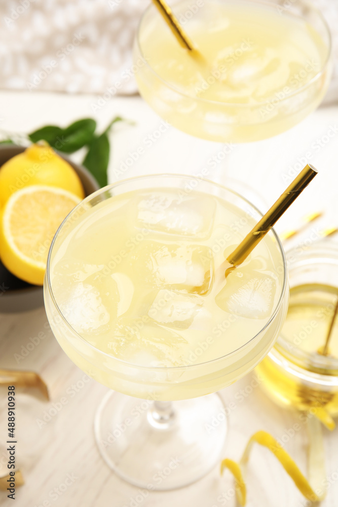 Delicious bee's knees cocktail and ingredients on white wooden table Delicious bee's knees cocktail and ingredients on white wooden table