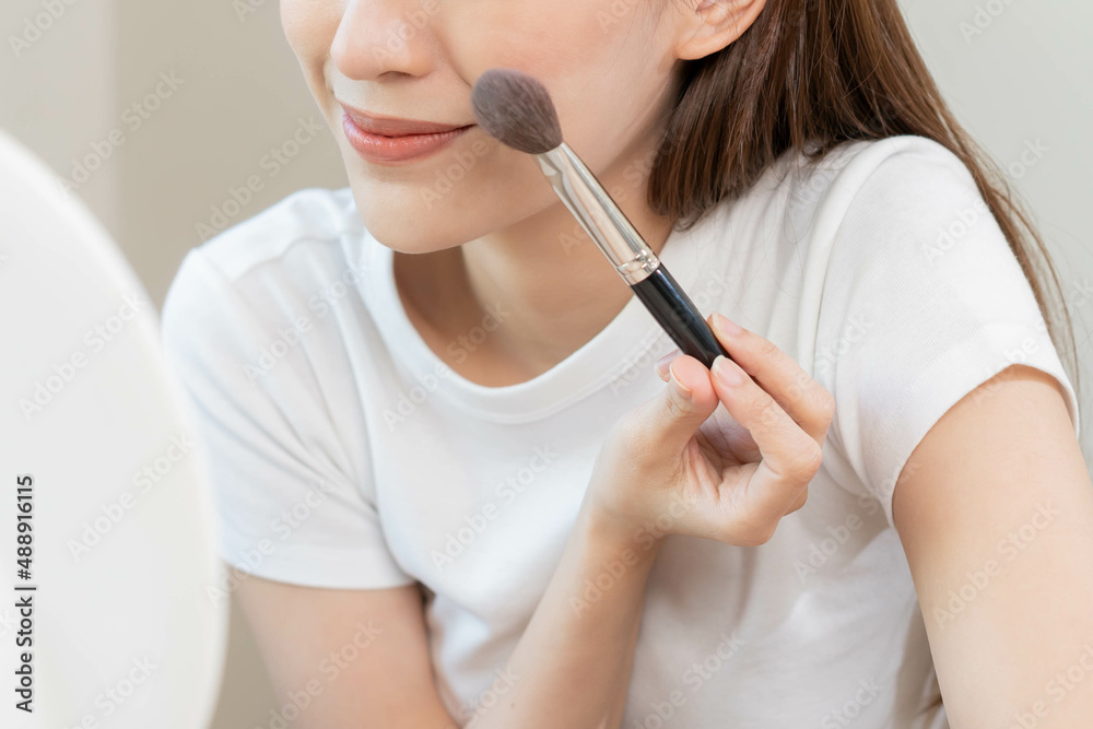 Happy beauty blogger concept, cute asian young woman, girl smile, make up face by applying brush blush powder on her cheek, looking at the mirror. People look with natural fashion style, copy space. Happy beauty blogger concept, cute asian young woman, girl smile, make up face by applying brush blush powder on her cheek, looking at the mirror. People look with natural fashion style, copy space.