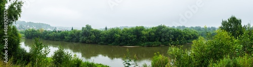 Beautiful panorama of morning on the calm river with village on their bank 