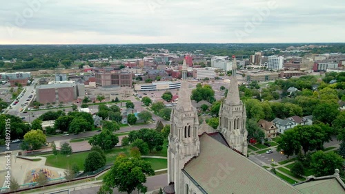 Panoramic view from above church in Sioux Falls, South Dakota. Residential neighborhood surrounding church and school. Businesses and apartment buildings farther out. Trees in the distance. photo