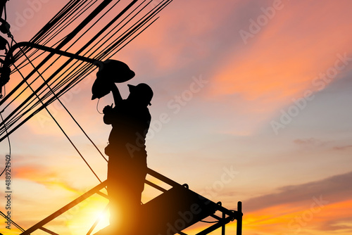 Quadro em tela Silhouette of Electrician checking lighting to the LED street lamp post, Technic