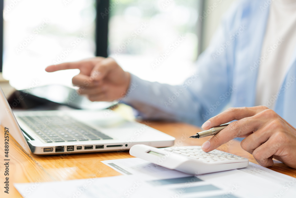 Business analyst concept the accountant using a calculator to estimate the amount of profits Business analyst concept the accountant using a calculator to estimate the amount of profits