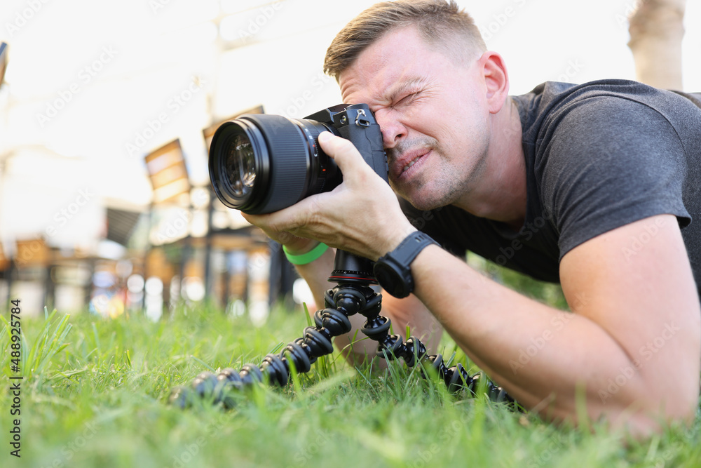 Photographer takes pictures with modern camera on tripod outdoors