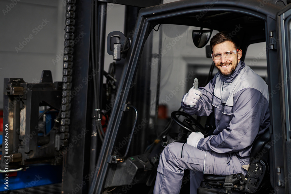 Portrait of happy forklift driver in factory giving thumbs up for on time delivery. Portrait of happy forklift driver in factory giving thumbs up for on time delivery.