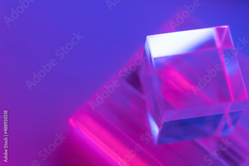 Luminous glass objects with multi-colored lighting. Neon background with geometric shapes, soft selective focus, copy space.