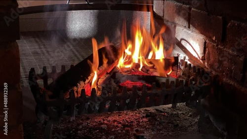 A roaring log fire burning in an open fireplace giving warmth on a clod winters day, Wngland. photo