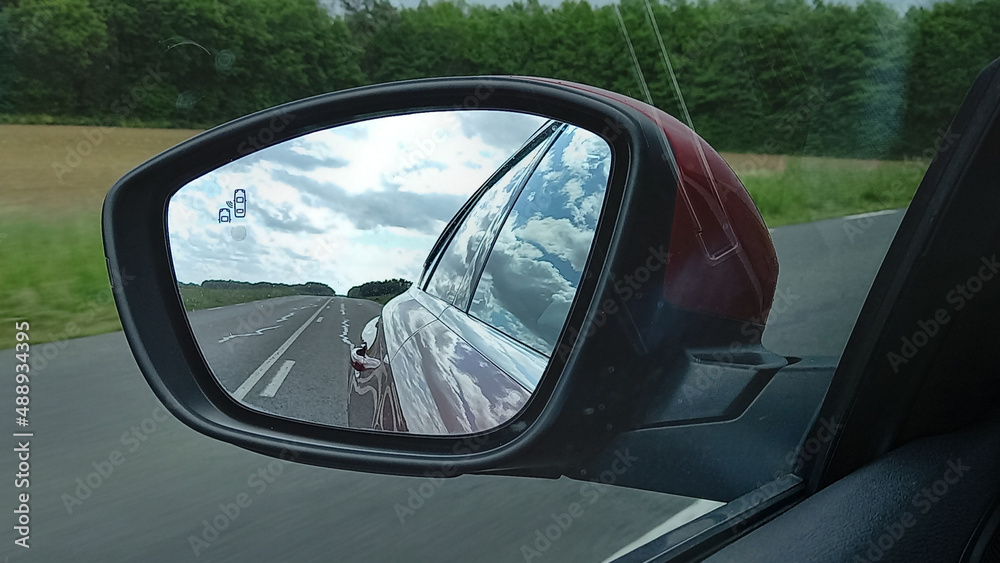 car rearview mirror modern vehicle in road view and clouds