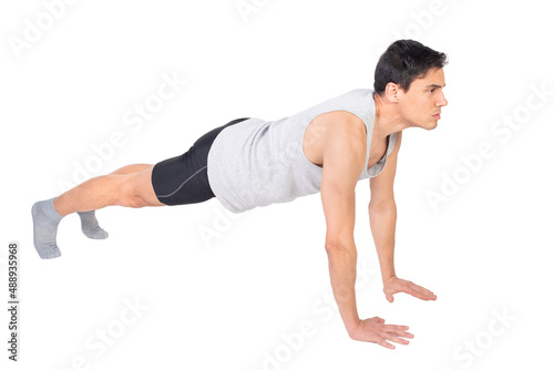 Strong sportsman doing push ups in studio