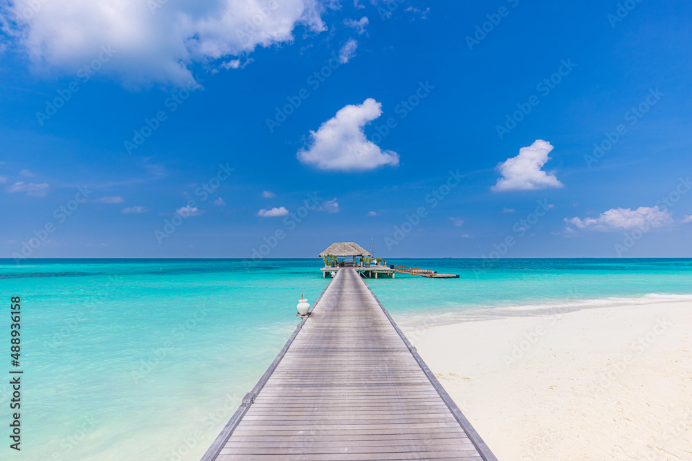 Overwater bungalow in the Indian Ocean, shore coast landscape. Tropical island beach, amazing blue sky, endless sea view, long jetty horizon exotic luxury vacation, summer travel destination, Maldives