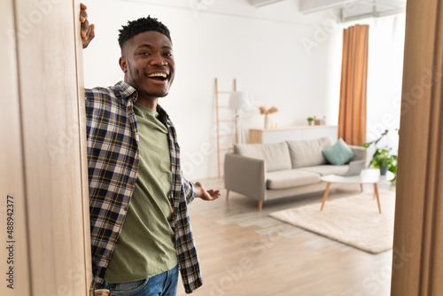Happy African American Man Opening Door Smiling Standing At Home