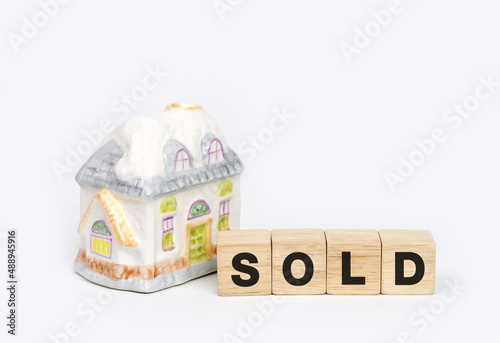 Home model and wooden cubes with alphabet SOLD. Selling a house, apartment. Trade of property. Real estate agent services. 