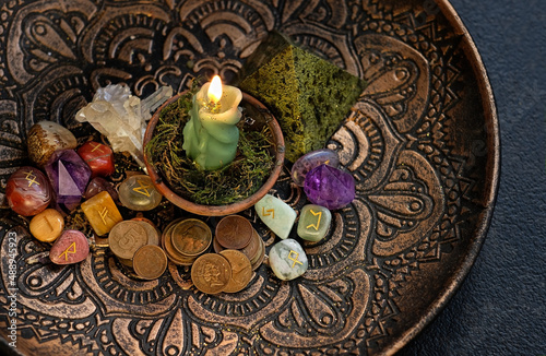 Witch altar with candles, different old coins, stone runes, crystals on dark table background. Magic for attracting money, wealth. witchcraft money esoteric ritual. occultism concept. top view
