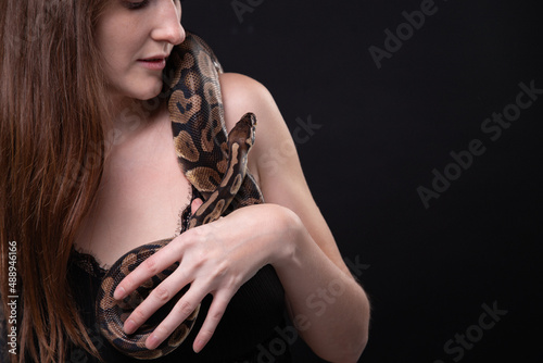 Photo of tender woman with snake on shoulder