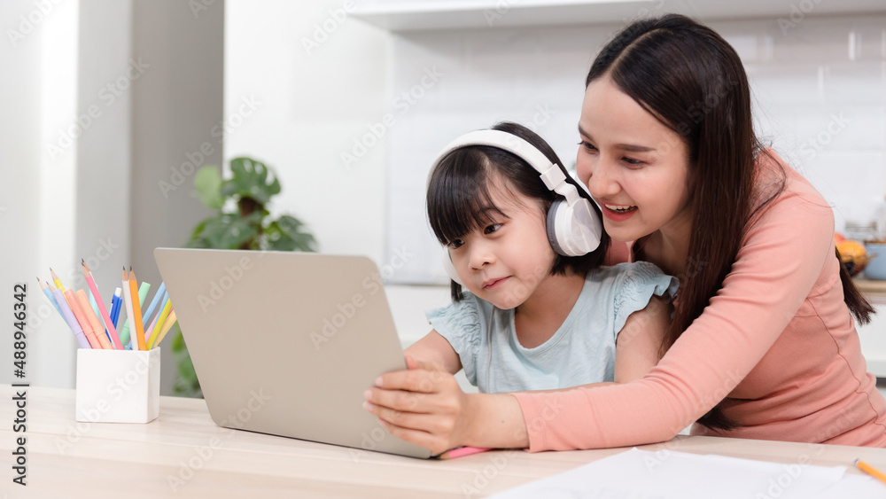 Beautiful Asian women moms and girls studying online Via internet from home By using a laptop And listen to the sound by headphones with family support. Beautiful Asian women moms and girls studying online Via internet from home By using a laptop And listen to the sound by headphones with family support.