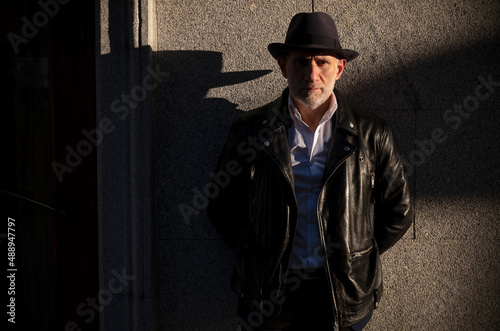 Portrait of adult man in hat and suit against wall on street. Madrid, Spain