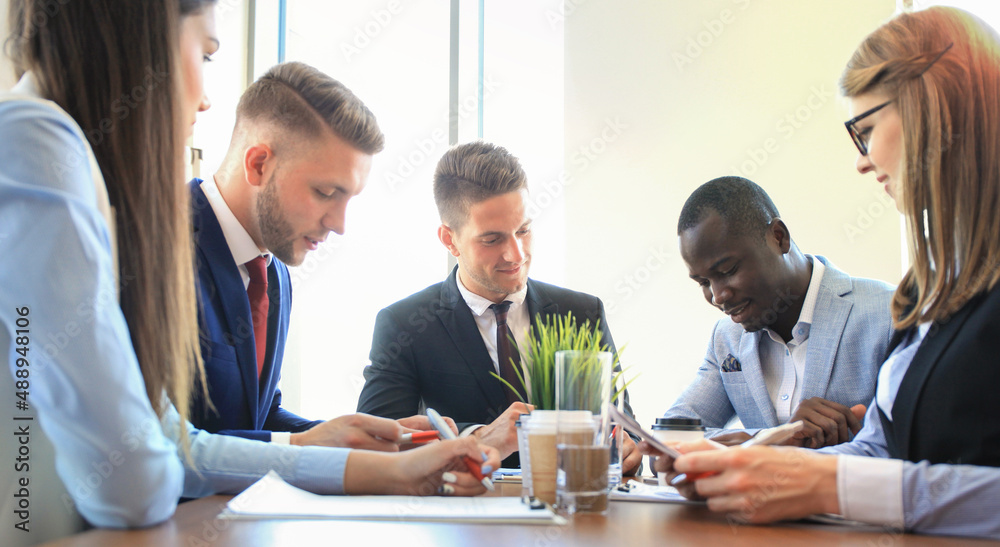 Business team discussing together business plans in office. Business team discussing together business plans in office.