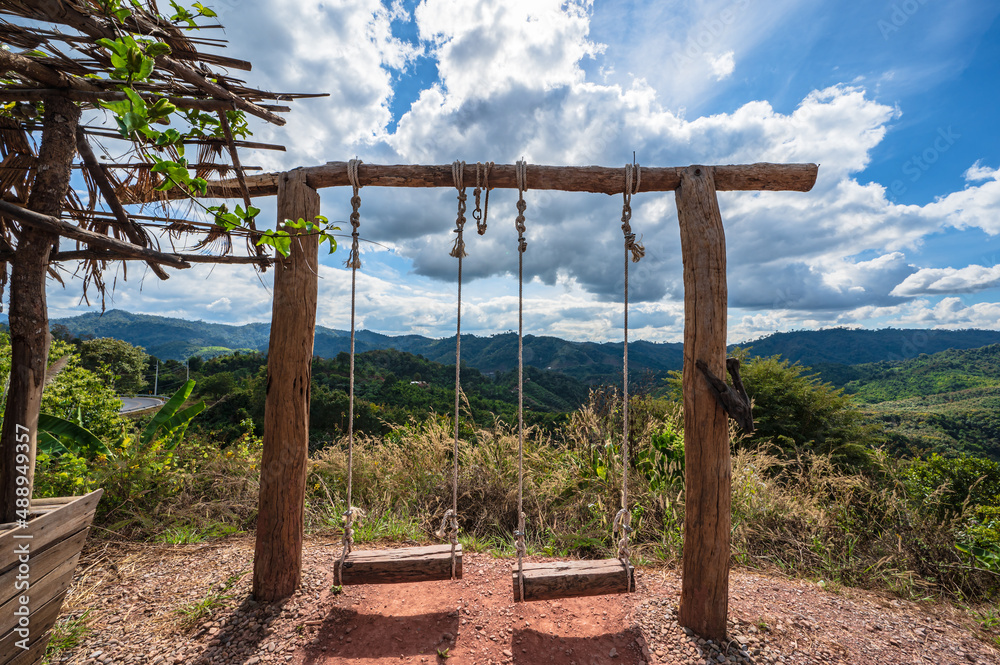 Wooden swing with beautiful landscape view and the valley of the mountain Wooden swing with beautiful landscape view and the valley of the mountain