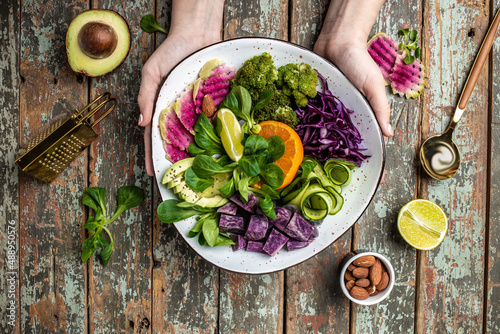 Photography Healthy vegetarian buddha bowl salad with halloumi cheese, avocado, cucumber, chickpeas, watermelon radish, potato purple sweet